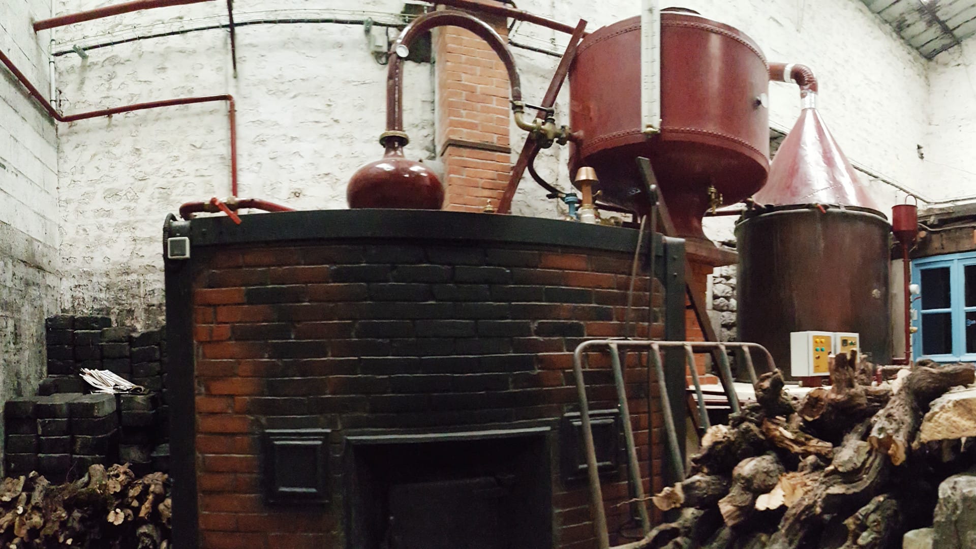 Alambic en cuivre fonctionnant encore au feu de bois, douce chaleur dans la distillerie Alambic en cuivre fonctionnant encore au feu de bois, douce chaleur dans la distillerie